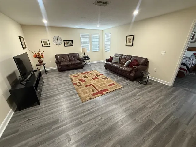 a living room with furniture and wooden floor