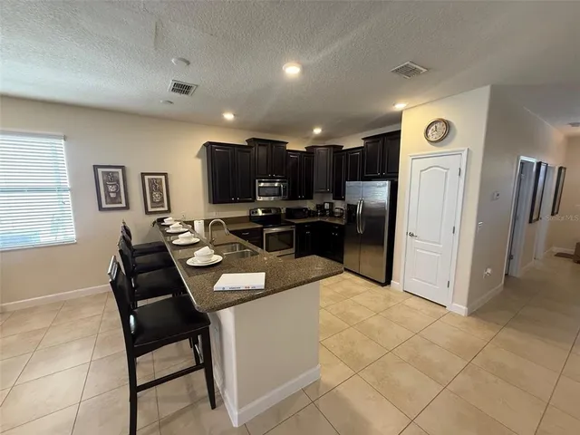 a kitchen with a refrigerator and a stove top oven