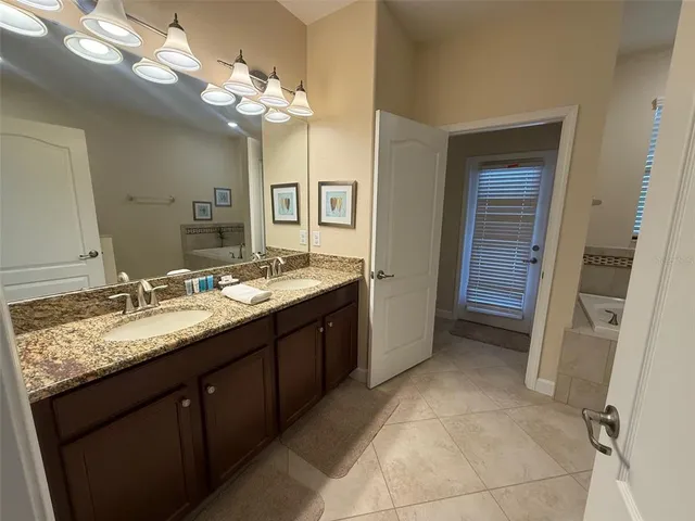 a bathroom with a granite countertop sink a large mirror and a shower