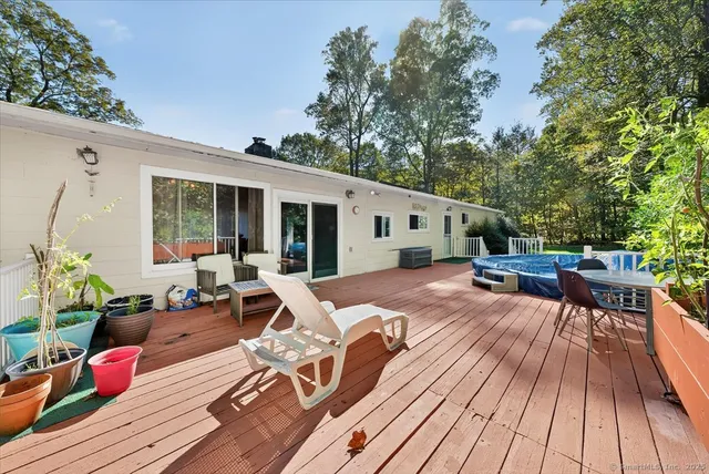 a view of a patio with wooden floor table and chairs