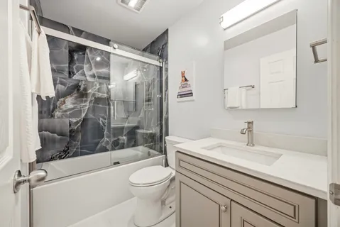 a bathroom with a sink a toilet and shower