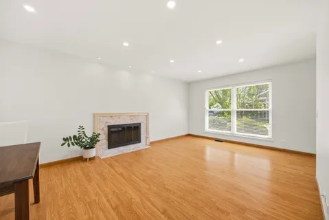 a view of an empty room with a fireplace and a window