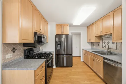 a kitchen with stainless steel appliances granite countertop a refrigerator sink and stove