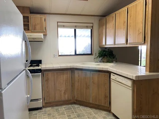 a kitchen with a sink a window cabinets and stainless steel appliances