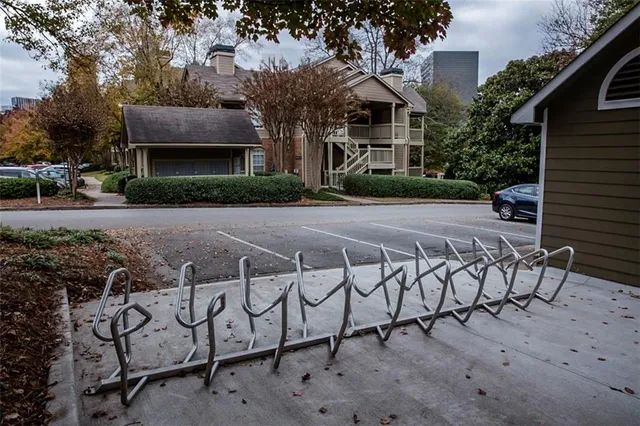 a view of a bench with table and chairs in front of house