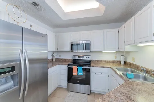 a kitchen with stainless steel appliances granite countertop a refrigerator sink and stove