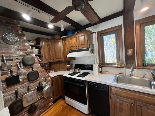 a kitchen with a sink appliances cabinets and a window