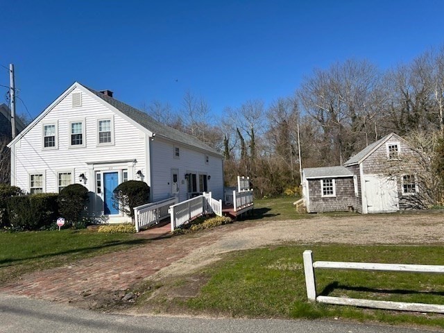 213 Main Street Chatham, MA 02633 - Photo 22 of 30 a view of a white house in front of a yard with plants and large tree