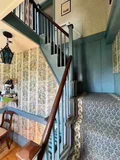 a view of staircase with wooden floor and white walls