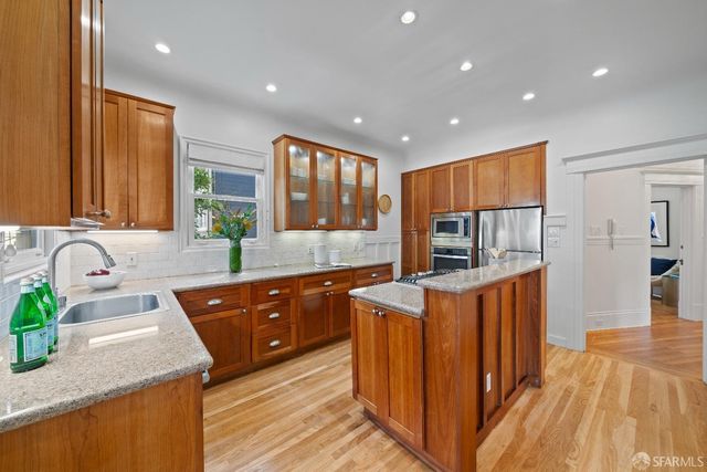a kitchen with stainless steel appliances granite countertop sink stove and refrigerator