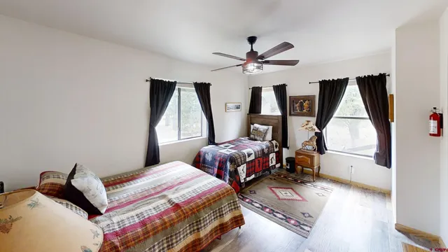a bedroom with a bed next to a window with a dresser