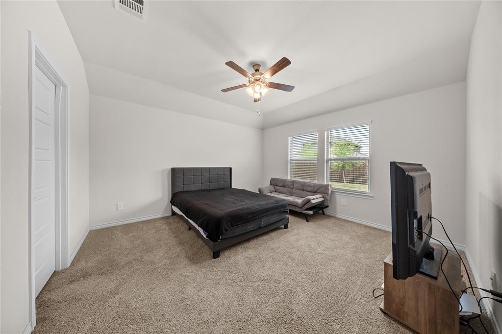 9805 Quail Pointe Road Aubrey, TX 76227 - Photo 14 of 38 Vaulted ceiling, ceiling fan, carpeted flooring, multiple windows, and a paneled door