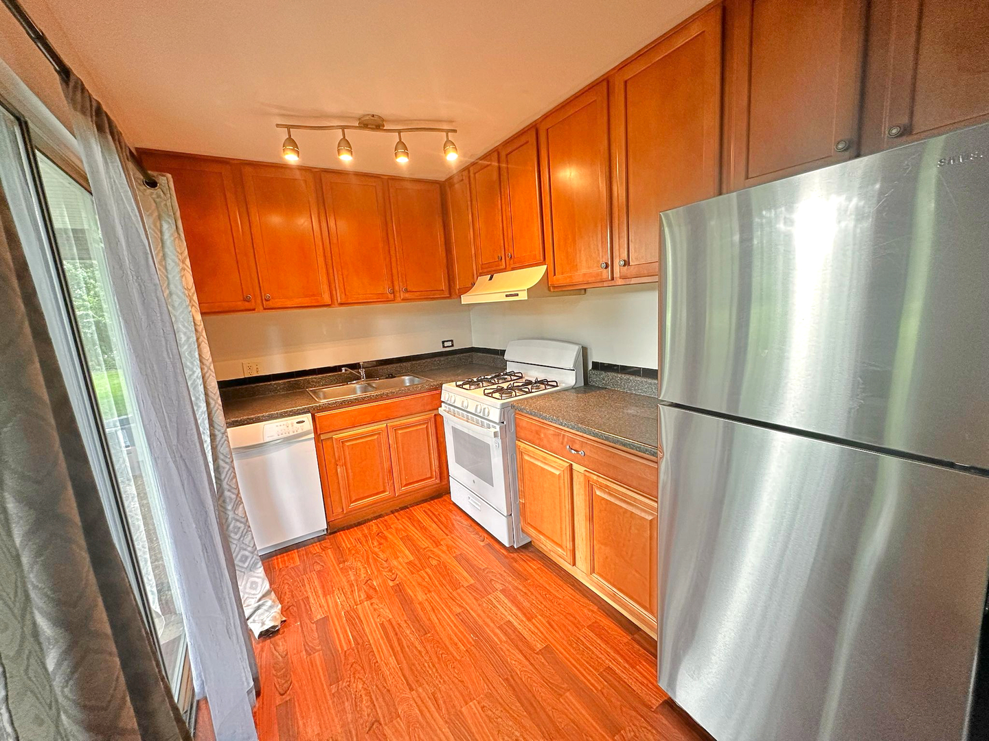 8 Gant Circle, Unit D Streamwood, IL 60107 - Photo 4 of 12 a kitchen with stainless steel appliances a refrigerator a sink a stove and white cabinets