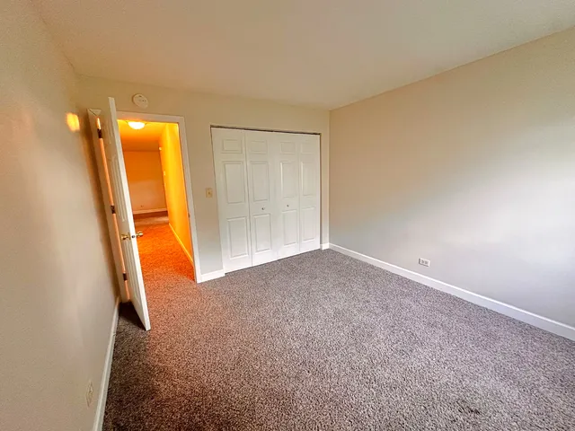 an empty room with a bathroom and mirror