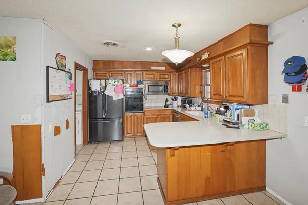 a kitchen with stainless steel appliances granite countertop a refrigerator a sink and a stove