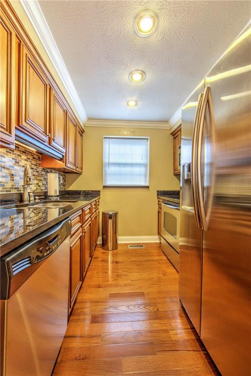 5497 Library Road, Unit 5 Bethel Park, PA 15102 - Photo 7 of 15 Modern kitchen featuring maple cabinets, hardwood floors, stainless steel appliances.