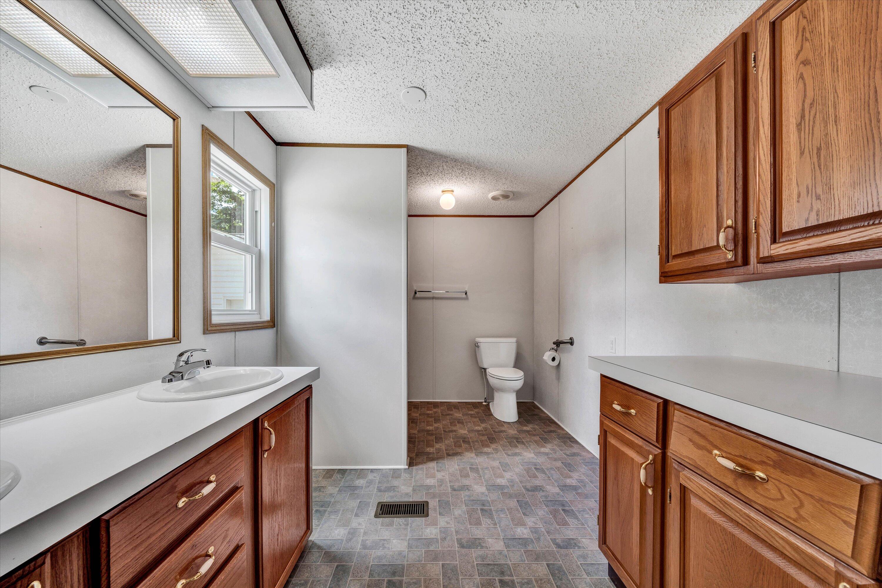 5232 Old Forge Road Rocky Mount, VA 24151 - Photo 20 of 41 a spacious bathroom with a double vanity sink a mirror and a toilet
