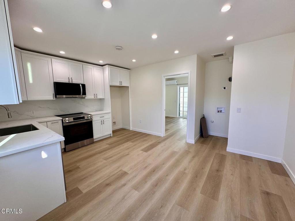 a large kitchen with stainless steel appliances granite countertop a stove and a sink