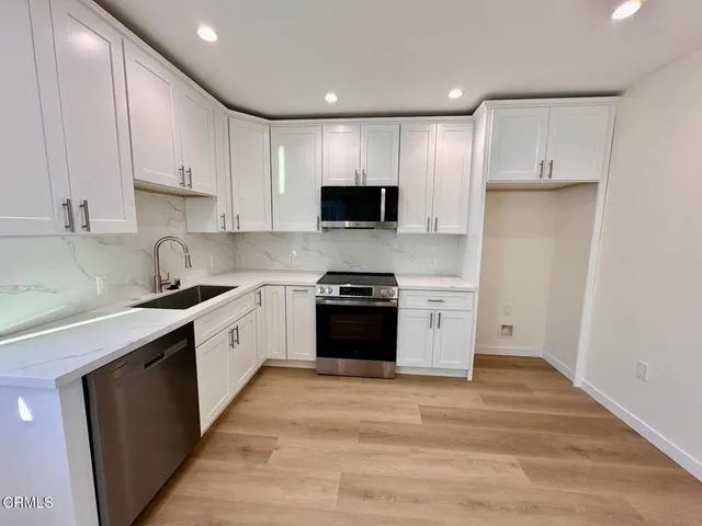 a large kitchen with a stove and a sink