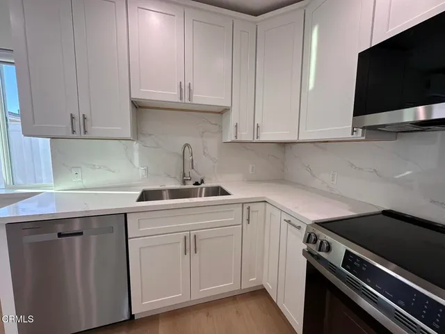 a kitchen with white cabinets and a stove top oven