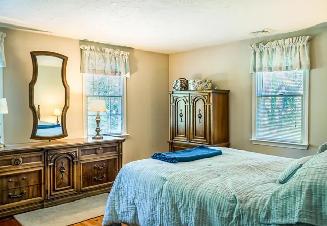 a bedroom with a bed next to a window