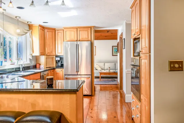 a kitchen with stainless steel appliances granite countertop a refrigerator and a table