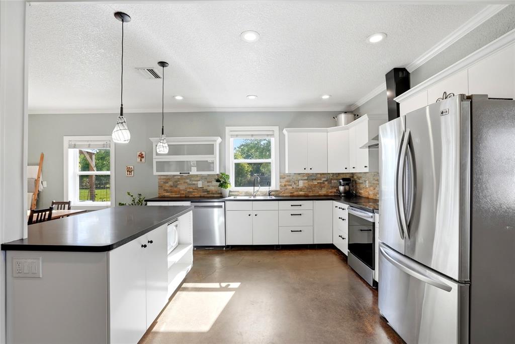 123 South Wiggins Road Plant City, FL 33566 - Photo 11 of 55 a white kitchen with granite countertop a refrigerator a sink a center island and furniture
