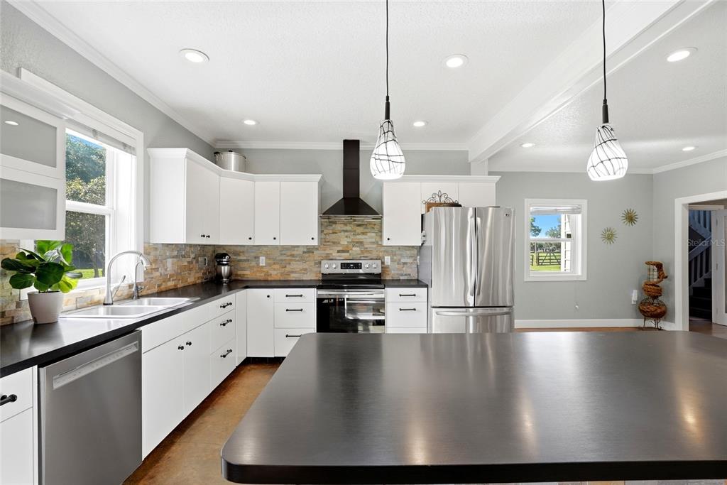 123 South Wiggins Road Plant City, FL 33566 - Photo 12 of 55 a kitchen with stainless steel appliances granite countertop a sink a stove and a wooden floors