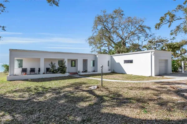a view of a house with backyard and a tree