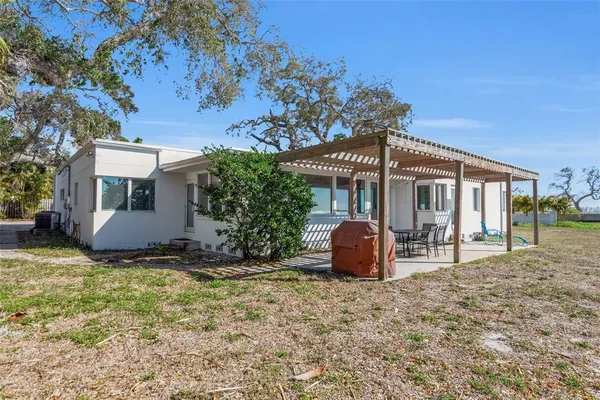 a view of a house with backyard and sitting area