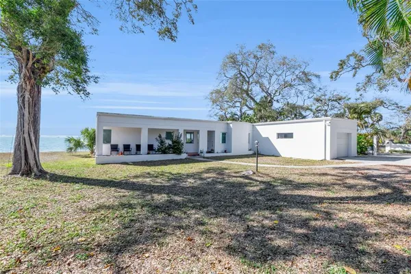 a view of a house with a yard and large tree
