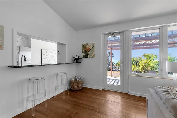 a view of an empty room with a window and a kitchen