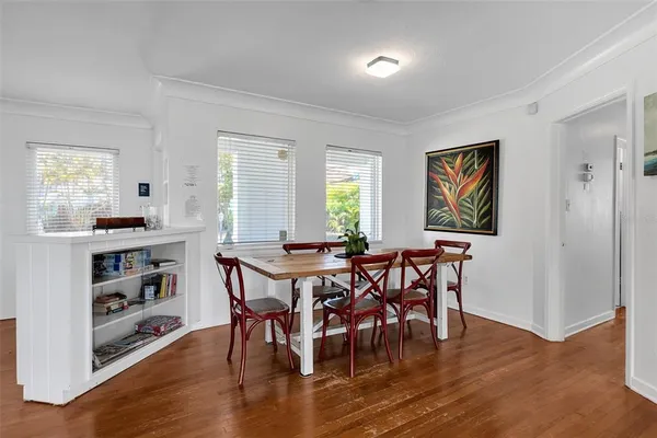 a view of a a dining room with furniture window and wooden floor