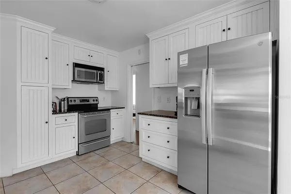a kitchen with white cabinets and stainless steel appliances