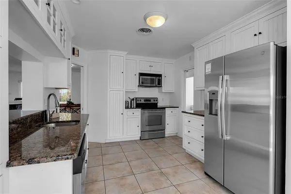a kitchen with granite countertop a refrigerator and a sink