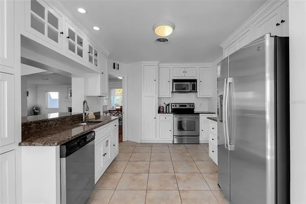 a kitchen with stainless steel appliances granite countertop a refrigerator and a stove