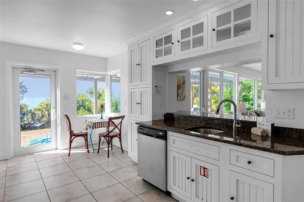 a kitchen with granite countertop a stove a sink and a cabinets
