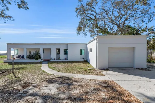 a view of a house with backyard and sitting area
