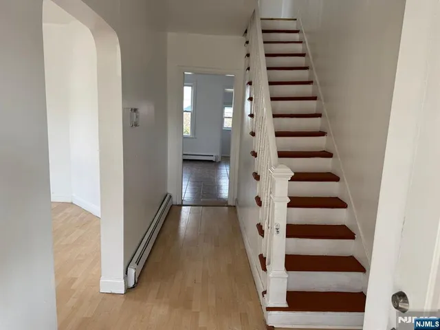 a view of a hallway with fireplace and stairs