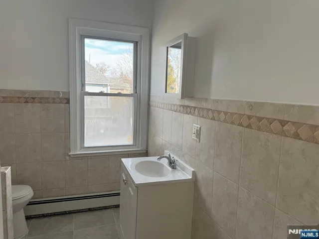 a bathroom with a sink a toilet and a window