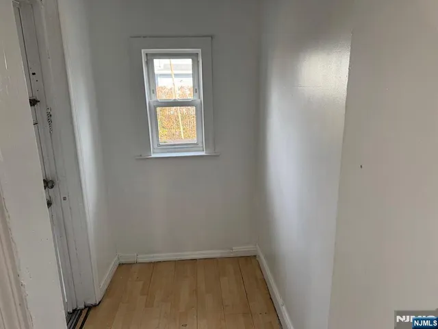 a view of a small space with wooden floor and a window