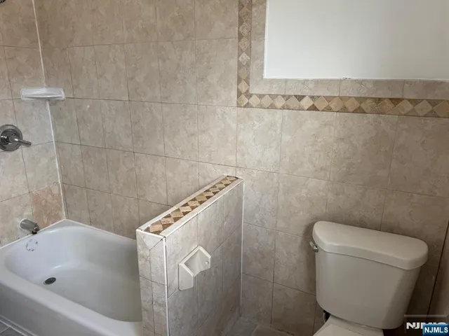 a bathroom with a toilet and bathtub