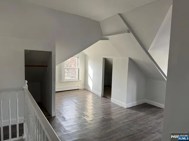 a view of hallway with stairs and wooden floor