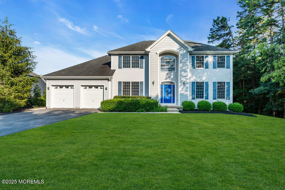 a front view of a house with a yard and trees