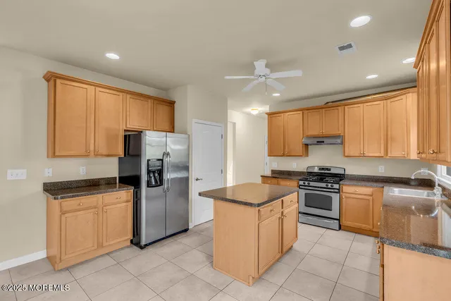 a kitchen with stainless steel appliances granite countertop a sink counter space cabinets and a large window