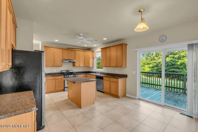 a large kitchen with kitchen island a large window appliances and cabinets