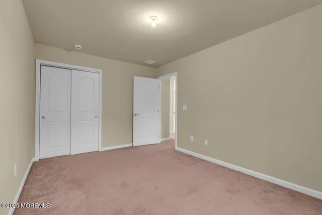 a spacious bedroom with a large bed and a chandelier