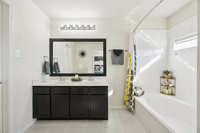 a bathroom with a bathtub sink and mirror