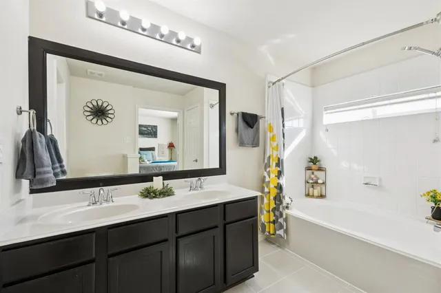 a bathroom with a tub a sink and mirror