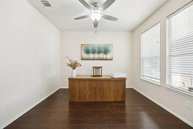a view of a workspace with furniture and a window